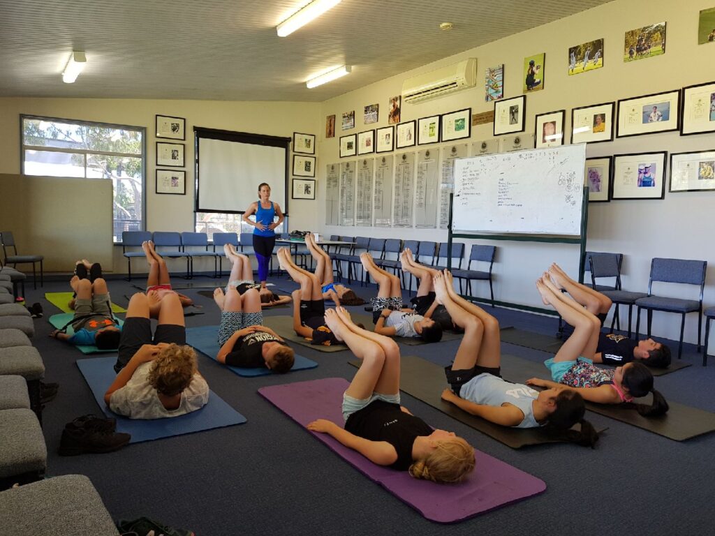 Young swimmers practicing pilates exercises on the mat